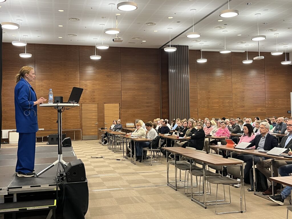 Yleisö kuuntelemassa luennoitsijaa.